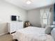 Bright bedroom with a white dresser, TV, large window, and chair at 372 Meadow Pointe Dr, Haines City, FL 33844