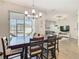 Bright dining area features modern chandelier, sliding glass doors and an open concept view of the living room at 372 Meadow Pointe Dr, Haines City, FL 33844