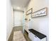 Hallway featuring wood floors, modern storage cabinet with bench, wall decorations, and front door at 372 Meadow Pointe Dr, Haines City, FL 33844