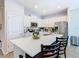 Well-lit kitchen island with seating, modern appliances, white cabinets, and stylish wood flooring at 372 Meadow Pointe Dr, Haines City, FL 33844