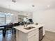 Open kitchen island with stainless steel sink, adjacent dining area, and view into living room at 372 Meadow Pointe Dr, Haines City, FL 33844