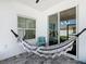 Charming covered patio with a cozy hammock and a small teal chair at 372 Meadow Pointe Dr, Haines City, FL 33844