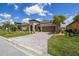 Inviting home with a well-maintained lawn and a brick-paved driveway leading to a two-car garage at 3775 Via Mazzini Ct, Kissimmee, FL 34759