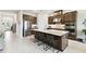 Bright, open kitchen features stainless steel appliances, an island with seating, and wood cabinetry at 3775 Via Mazzini Ct, Kissimmee, FL 34759