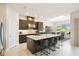 Modern kitchen featuring a large island with seating, stainless steel appliances, and a view into the dining area at 3775 Via Mazzini Ct, Kissimmee, FL 34759