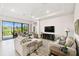 Bright living room featuring a tray ceiling, light wood floors, and sliding doors leading to outdoor area at 3775 Via Mazzini Ct, Kissimmee, FL 34759