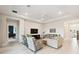 Open-concept living room with a tray ceiling, light wood floors, and comfortable seating arrangement at 3775 Via Mazzini Ct, Kissimmee, FL 34759