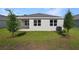 Backyard view of home featuring a manicured lawn and young trees at 4075 Bannock Ave, Tavares, FL 32778