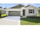 Beautiful home featuring stone accents, a gray garage door, and a well-manicured lawn at 4075 Bannock Ave, Tavares, FL 32778