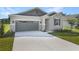 Beautiful home featuring stone accents, a gray garage door, and a well-manicured lawn at 4075 Bannock Ave, Tavares, FL 32778