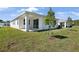 The backyard features a covered porch and new tree plantings at 4076 Bannock Ave, Tavares, FL 32778