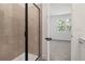 Modern bathroom featuring a glass-enclosed shower with beige tile and black hardware and neutral wall-to-wall carpeting at 4076 Bannock Ave, Tavares, FL 32778