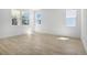 Bright bedroom with wood-look flooring and three large windows at 4076 Bannock Ave, Tavares, FL 32778