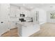 Modern kitchen featuring white cabinets, an island, and stainless steel appliances at 4076 Bannock Ave, Tavares, FL 32778