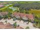 Aerial view of townhomes surrounded by lush green landscapes and a tranquil pond, showcasing a peaceful community at 4751 Terrasonesta Dr, Davenport, FL 33837
