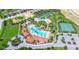 Aerial view showcasing community amenities with large pools, tennis courts, and lush landscaping in a neighborhood at 4751 Terrasonesta Dr, Davenport, FL 33837