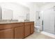 Well-lit bathroom featuring double sinks, granite countertops, and a glass-enclosed shower at 4751 Terrasonesta Dr, Davenport, FL 33837