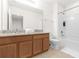 Bright bathroom featuring a granite vanity top, under-sink storage, and a shower/tub combo with white tile at 4751 Terrasonesta Dr, Davenport, FL 33837