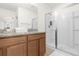 Well-lit bathroom featuring double sinks, granite countertops, and a glass-enclosed shower at 4751 Terrasonesta Dr, Davenport, FL 33837