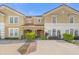 Inviting townhome showcasing a Mediterranean-style facade and well-manicured landscaping under a clear blue sky at 4751 Terrasonesta Dr, Davenport, FL 33837