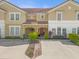 Charming townhome showcasing a red tile roof, covered entry, and well-maintained landscaping at 4751 Terrasonesta Dr, Davenport, FL 33837