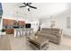 Open-concept living room features a comfortable tan sofa, adjacent to the kitchen with pendant lighting and barstool seating at 4751 Terrasonesta Dr, Davenport, FL 33837