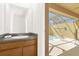 Powder room featuring a single sink, decorative mirror, and convenient access to the screened-in pool area at 4751 Terrasonesta Dr, Davenport, FL 33837
