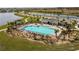 Aerial view of community pool with lounge seating next to a lake at 5140 Four Strand Ct, St Cloud, FL 34772
