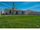 Spacious backyard features a well-maintained lawn, a young tree, and a partial view of the rear of the house at 5140 Four Strand Ct, St Cloud, FL 34772