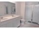 Bright bathroom with double sink vanity, shower, and tile floor with white walls at 5140 Four Strand Ct, St Cloud, FL 34772