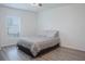 Cozy bedroom boasts a soft bed with patterned bedding, light walls, and a view from a large window at 5140 Four Strand Ct, St Cloud, FL 34772