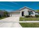 A well-maintained single-story home with a two-car garage, complemented by a green lawn and landscaping at 5140 Four Strand Ct, St Cloud, FL 34772