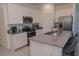 Bright kitchen featuring stainless steel appliances, white cabinets, and a large center island with sink at 5140 Four Strand Ct, St Cloud, FL 34772