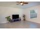 Spacious living room featuring a ceiling fan, neutral tile flooring and large window overlooking the lawn at 5140 Four Strand Ct, St Cloud, FL 34772