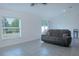 Bright living room features tile floors, a plush gray sofa, and large windows letting in natural light at 5140 Four Strand Ct, St Cloud, FL 34772
