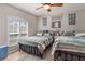 Bright bedroom featuring two beds, a large window with shutters, and neutral decor at 6017 Hickory Grove Ln, Port Orange, FL 32128