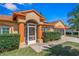 Charming single-story home showcasing a well-manicured front yard, terra cotta roof, and inviting screened porch entrance at 6017 Hickory Grove Ln, Port Orange, FL 32128