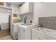Practical laundry area equipped with modern washer, dryer, utility sink, and overhead cabinets at 6017 Hickory Grove Ln, Port Orange, FL 32128