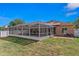 Backyard view featuring a large screened-in pool and patio area, set against a well-maintained lawn at 6017 Hickory Grove Ln, Port Orange, FL 32128