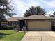 Charming single-story home featuring a two-car garage, landscaped yard, and neutral color palette at 610 Yak Ct, Kissimmee, FL 34759