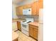 Bright kitchen featuring wood cabinets, tile flooring, and modern white appliances for convenience at 610 Yak Ct, Kissimmee, FL 34759