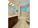 Well-lit bathroom features a vanity with dark wood cabinets and a shower-tub combination with tile surround at 6608 Harper Way, Harmony, FL 34773