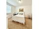 Bright bedroom featuring a large window, white furniture, and a cozy bed with decorative pillows at 6608 Harper Way, Harmony, FL 34773