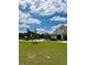 Expansive green lawn and walking path to community center and play area under sunny blue skies at 6608 Harper Way, Harmony, FL 34773