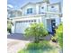 Two-story home with neatly trimmed landscaping and a brick driveway leading up to the two-car garage at 6608 Harper Way, Harmony, FL 34773