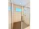 Walk-in shower featuring neutral tile and glass enclosure at 6608 Harper Way, Harmony, FL 34773