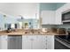 Bright kitchen with stainless steel appliances, white cabinets, and a breakfast bar overlooking living area at 675 Celebration Ave, Celebration, FL 34747