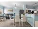 Open concept living area features a glass dining table, grey sofa, and stainless steel appliances at 675 Celebration Ave, Celebration, FL 34747