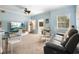 Bright living room featuring a glass-top dining table, plush gray sofa, and light blue accent walls at 675 Celebration Ave, Celebration, FL 34747