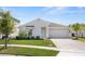 Inviting single-story home with a well-manicured lawn, white exterior, and a two-car garage, showcasing curb appeal at 739 Peg Ct, St Cloud, FL 34772